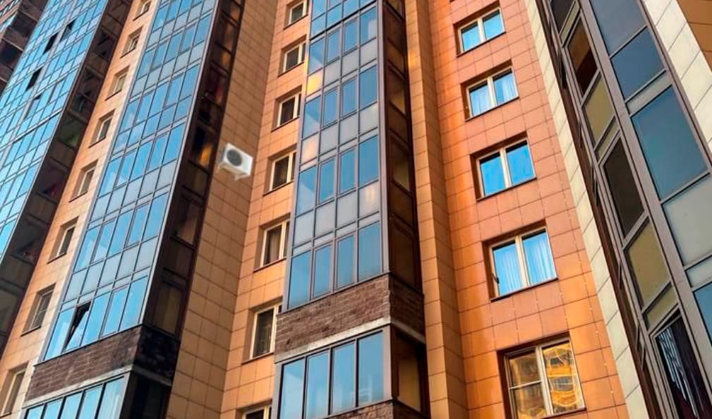 Установленный наружный блок на облицованной панели рядом с окном